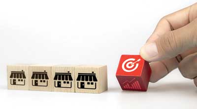 multipule wooden blocks with storefront image printed on them and one with marketing bullseye.