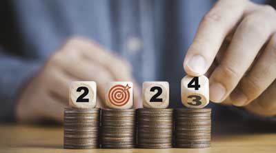Save Download Preview Businessman hand flipping wooden block cube from 2023 to 2024 on coins